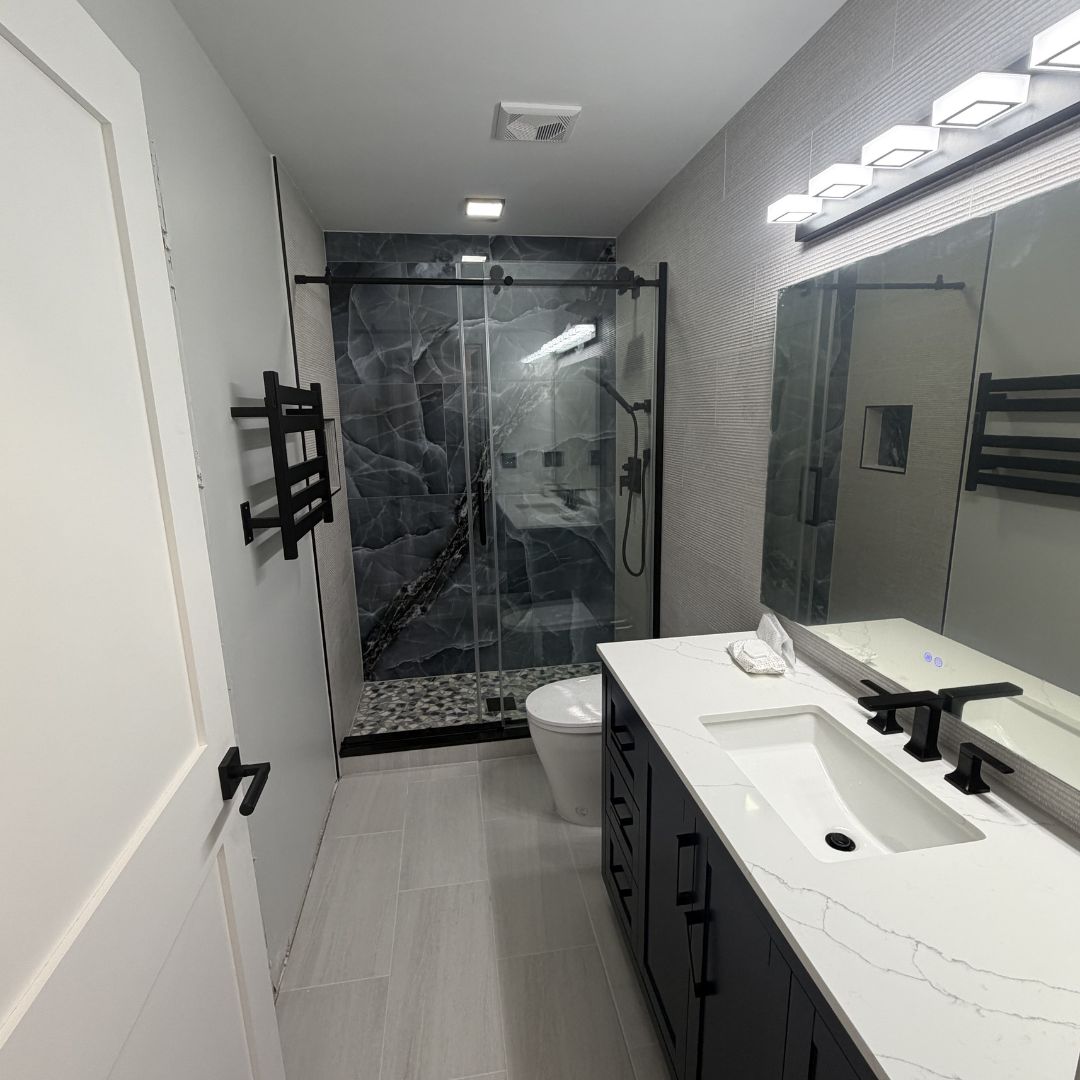 Dark marble shower with vanity and modern fixtures